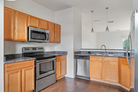 A kitchen with wooden cabinets and black appliances.